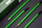 A set of Blackwing Lab 08.25.22 green pencils next to the packaging